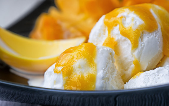 white ice cream with a sauce of ripe mango fruit