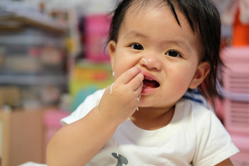 Happy baby eating himself. Asian cute baby eating food.
