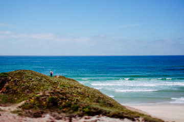 Fototapeta na wymiar Mann mit Surfbrett an der Küste Portugals, Peniche, Baleal