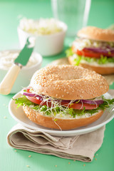 tomato sandwich on bagel with cream cheese onion lettuce alfalfa sprouts