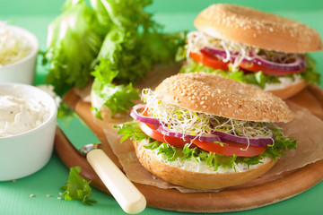 tomato sandwich on bagel with cream cheese onion lettuce alfalfa sprouts