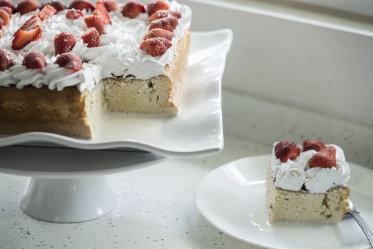 Closeup of Tres Leches cake decorated with strawberry and whipped cream