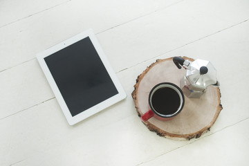Workspace digital tablet on the table with blank screen on wooden table with cup