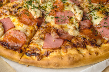 Close up of pizza with meat ingredients: ham, bacon, chicken breast