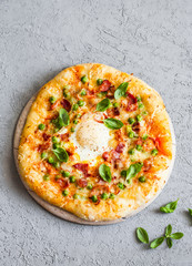Pizza with bacon, mozzarella, green peas and egg on grey background, top view. Tasty breakfast, snack or appetizer. Copy space