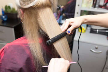 Fototapeta premium Stylist puts women's hair on a plate
