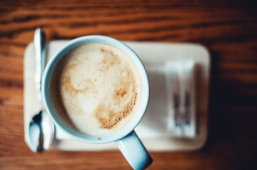 A blue vintage cup of coffee latte on wooden table
