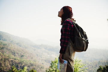 Young woman traveller with backpack in a woods. Hiking at summertime.