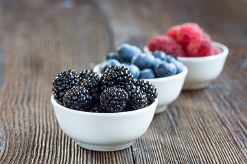 Fresh berries in bowls on a rustic wooden table