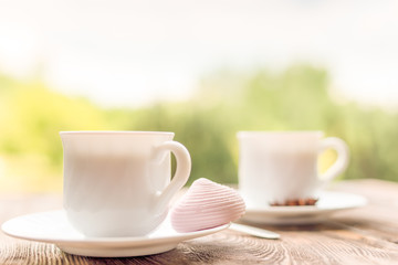 Two cups of  tea and marshmallow on rustic wooden table