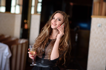 Pretty girl talking on the phone at the restaurant.