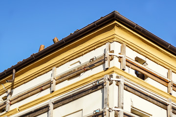 Facade of an old italian masonry building with metal tie-rod, containment straps and anchor plate.