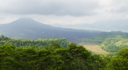 Sunrise in Amed, Bali, Indonesia. The active volcano Gunung Agung looms over the black sand beach of Jemeluk in the area known as Amed in the eastern shore of the tropical island of Bali.