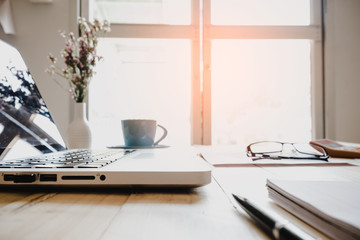 Laptop, calculator with financial documents on wooden table