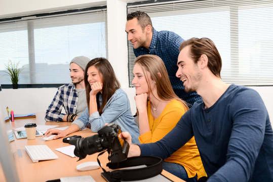 group of five young people student with their teacher in photography school learning photo editing with desktop computer, camera and photo equipment