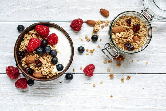 homemade yogurt with oat granola, nuts and fresh berries in a bowl