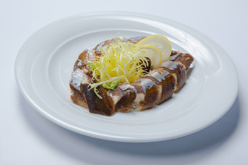 slices of smoked fish mackerel or scomber on a white rectangular dish