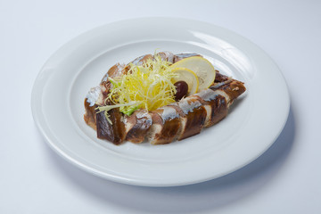 slices of smoked fish mackerel or scomber on a white rectangular dish