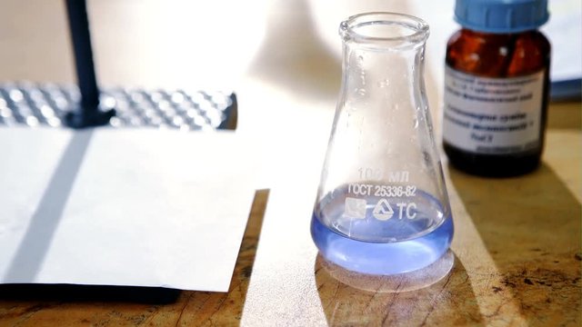 Scientist working at the laboratory with burette, Chemistry laboratory glassware and blur background.