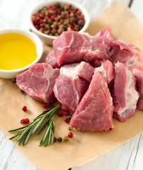 raw pork neck meat cut in pieces on wooden table