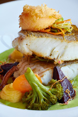 White stewed pikeperch fish in green pesto sauce with vegetables for steaming broccoli, carrots, beets, mushrooms, mashed potatoes close up