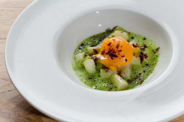 Flüssiger Eidotter auf Spargelgemüse mit Bärlauch