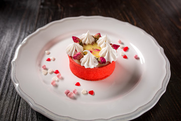 Caramel cheesecake with cream and flowers on the wooden background