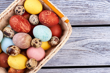 Easter basket on wooden background. Top view of egg pile. Easter picnic food ideas.