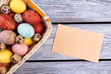 Blank card and Easter basket. Empty paper, gray wood background. Invite friends for Easter picnic.