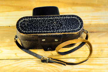 Old soviet rangefinder camera in leather case ona wooden table
