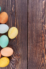 Colored eggs on brown wood. Easter eggs with copyspace.