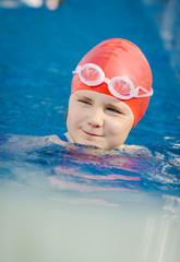 Young girl learning to swim in the pool