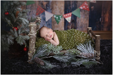 A cute tiny baby is having his first professional photoshoot and he is covered with a green blanket. He is sleeping.