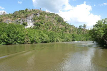 Canal on hot weather day with blue and cloudy sky.
