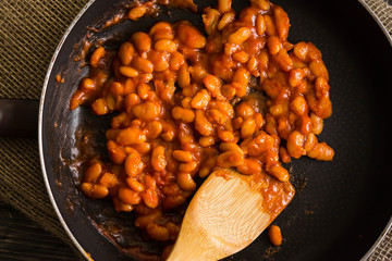 Beans in tomato in a frying pan. A delicious dish.