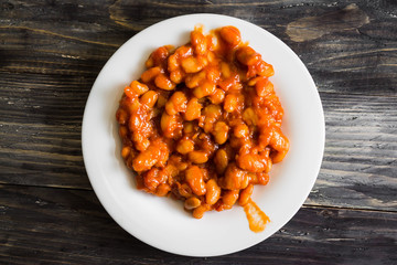 Beans in tomato in a white plate. A delicious dish.