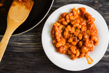 Beans in tomato in a white plate. A delicious dish.