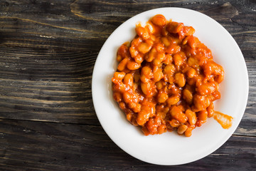 Beans in tomato in a white plate. A delicious dish.