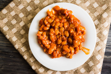 Beans in tomato in a white plate. A delicious dish.