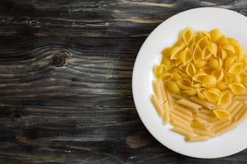 Raw pasta on a wooden table. Different types of pasta.