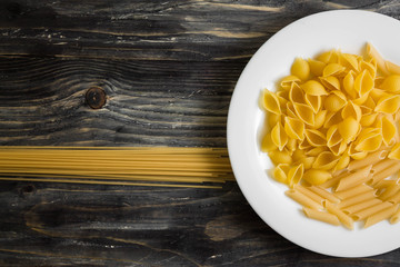 Raw pasta on a wooden table. Different types of pasta.