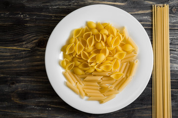 Raw pasta on a wooden table. Different types of pasta.