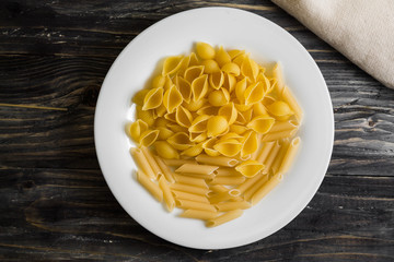 Raw pasta on a wooden table. Different types of pasta.