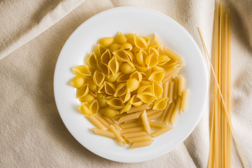Raw pasta on a white sacking. Different types of pasta.