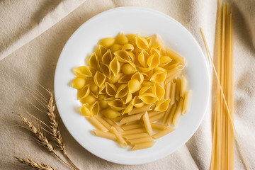Raw pasta on a white sacking. Different types of pasta.