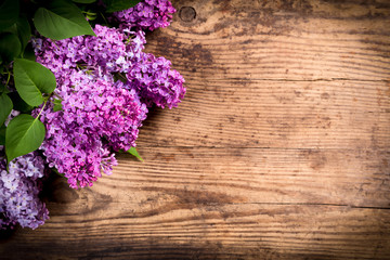 Lilac flowers in corner of dark brown wood table