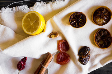Dried slices of lemon, coffee beans, cinnamon, leaf tea, dried fruits and nuts on a wooden table. Natural product.