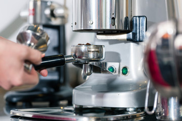 Waiter preparing espresso at an automatic coffee machine