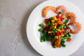 Shrimps with vegetables on a wooden table in rustic style