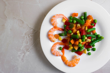 Shrimps with vegetables on a wooden table in rustic style